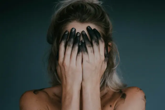 woman covering face with both hands closeup photography